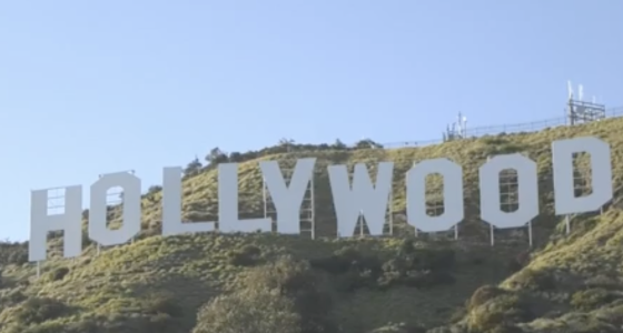 The image shows the famous Hollywood Sign situated on the hills of Los Angeles, California. The iconic white letters spell "HOLLYWOOD" and are positioned on the southern slope of Mount Lee in the Hollywood Hills area of the Santa Monica Mountains.